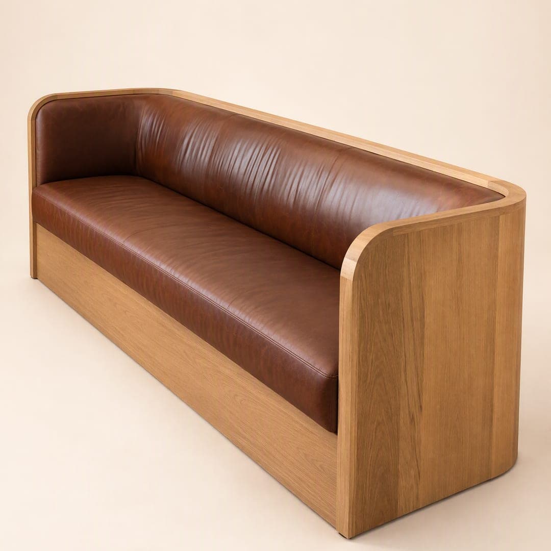 A lounge sofa with curved solid timber sides and a brown leather seat and back