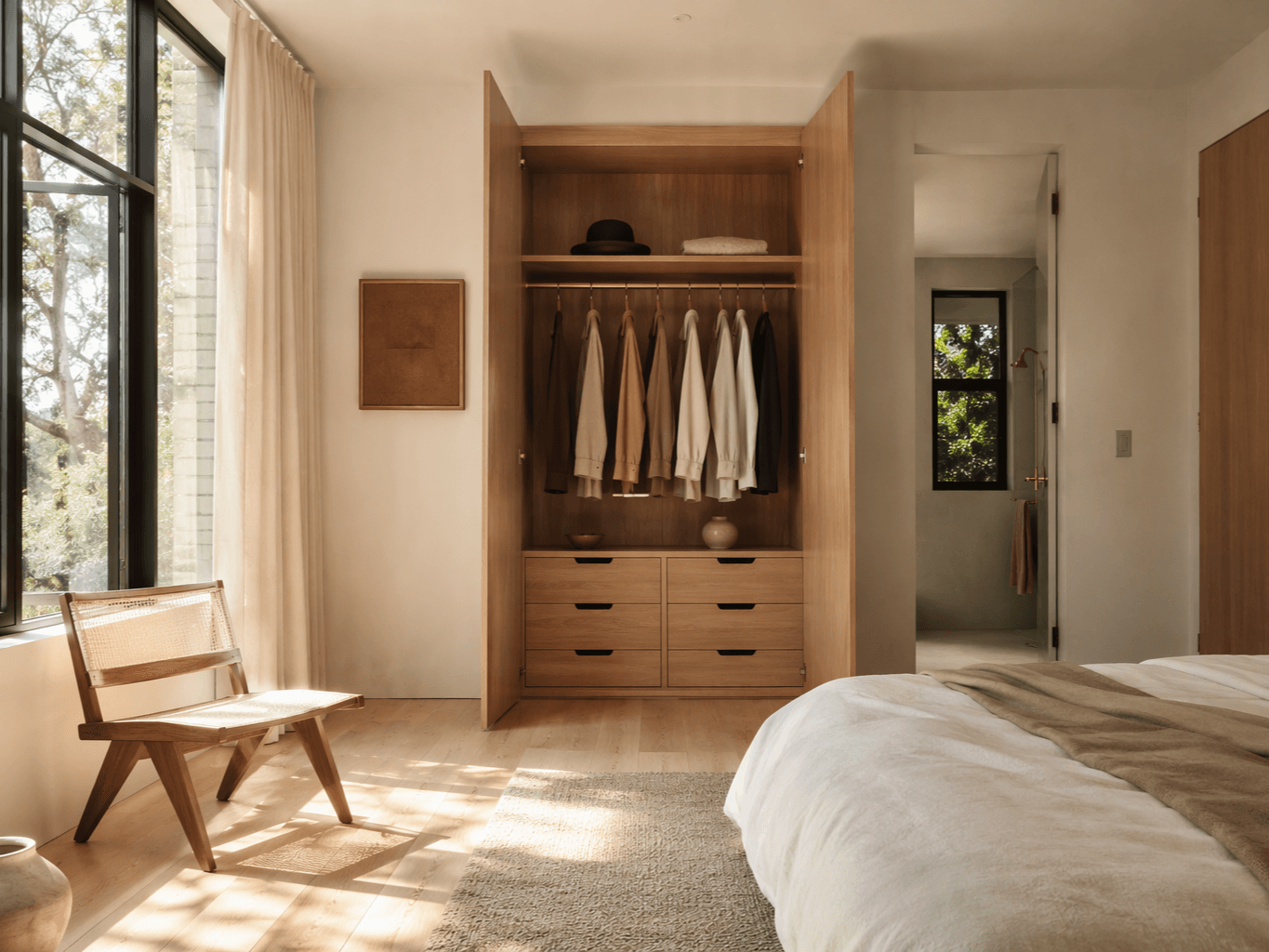 A fitted wardrobe with doors open, oak interior