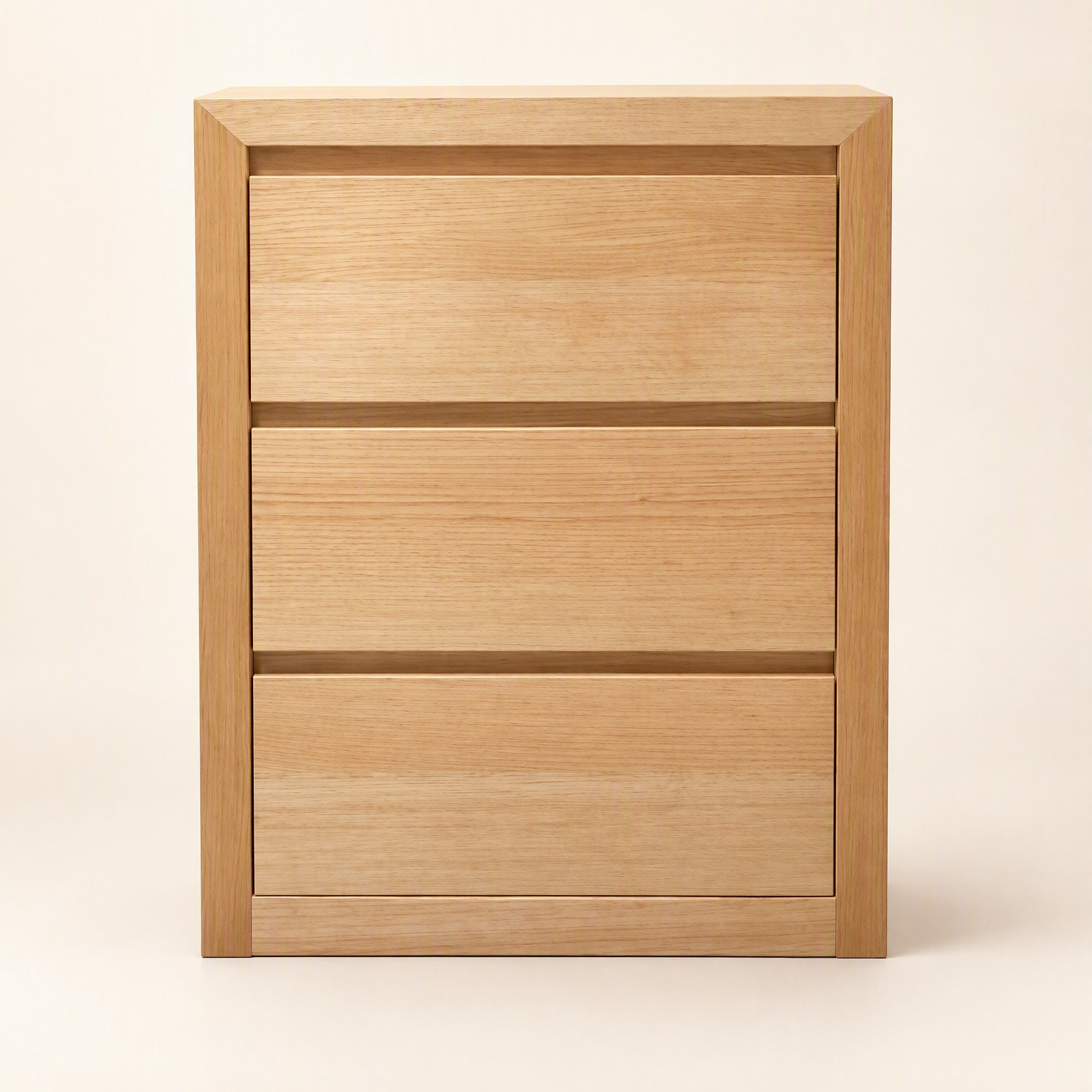 A three-drawer bedside in pale timber with a flush, handleless front