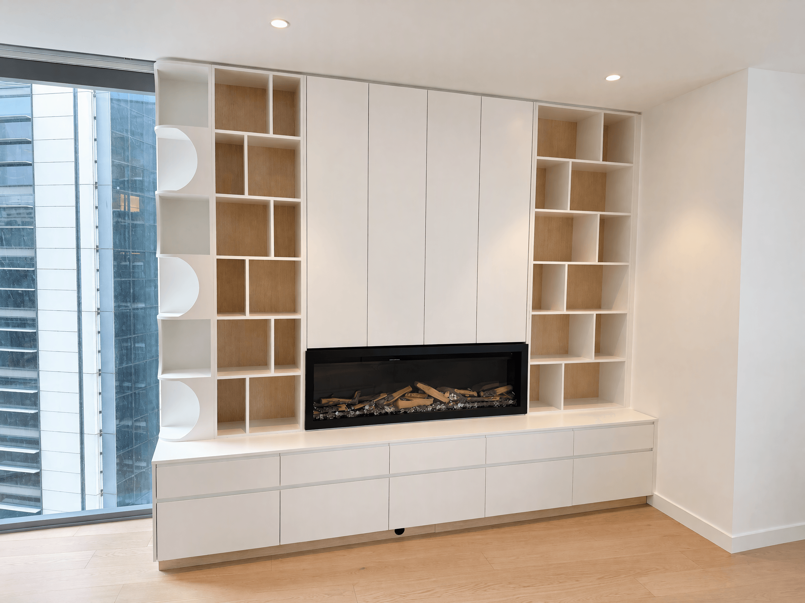 White apartment wall unit with a built-in fireplace, open timber cubbies and drawers below