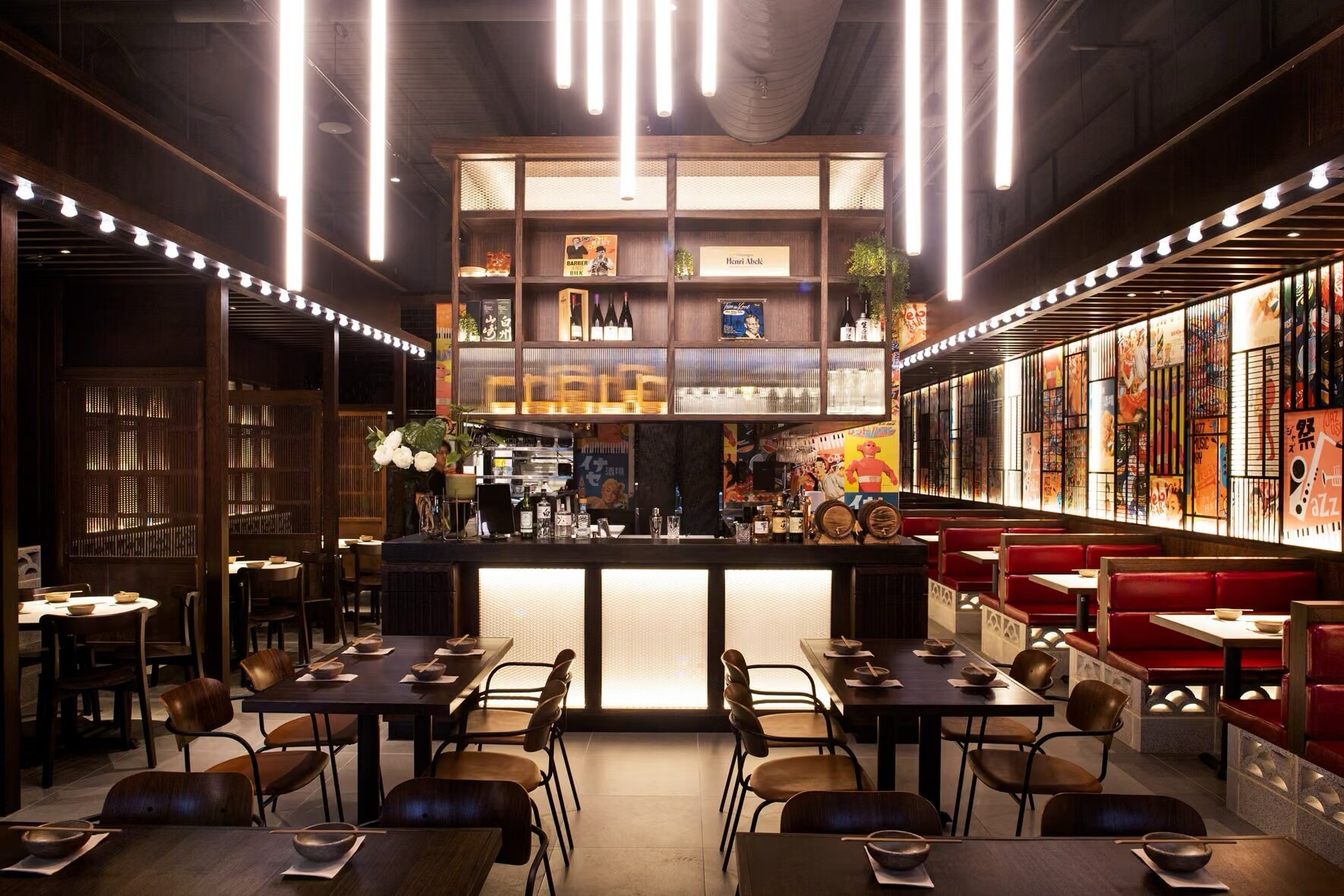 Japanese restaurant with a lit back bar, red booths and timber ceiling battens