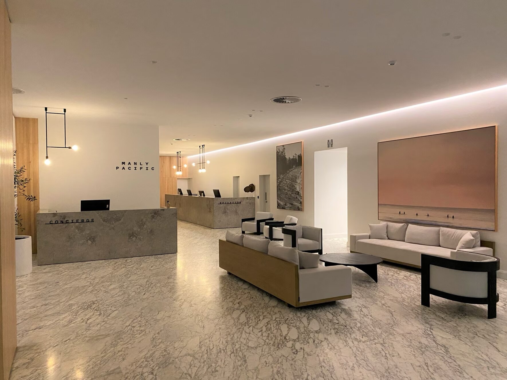 Hotel lobby with a stone reception desk, lounge seating and artwork