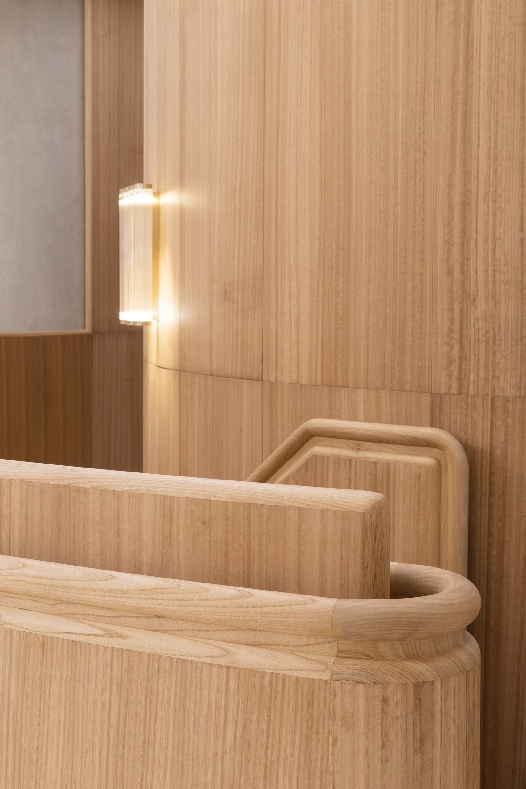 Valentino boutique stair with a timber-lined wall and rounded handrail