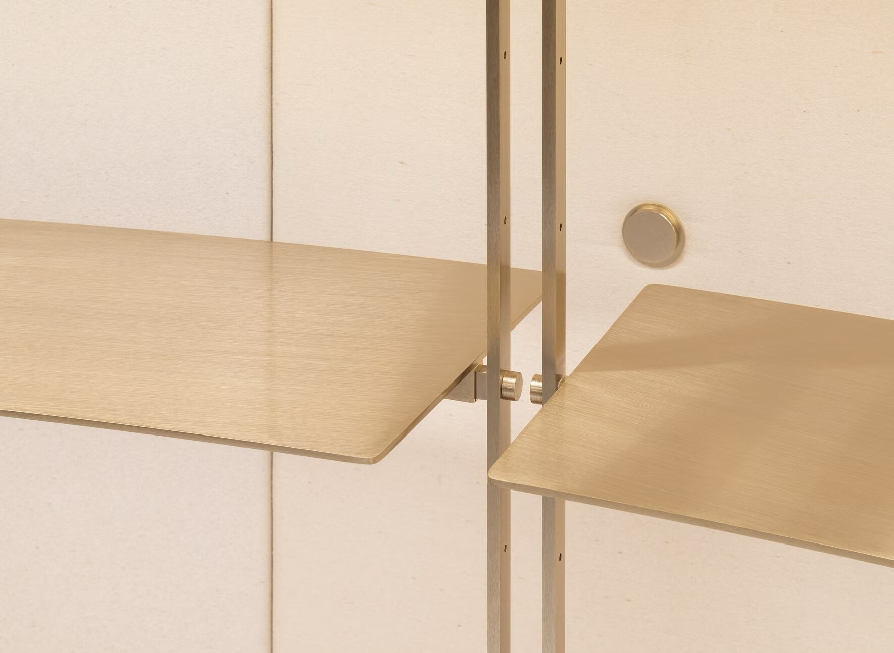 Close-up of brass shelf brackets on a Valentino display wall
