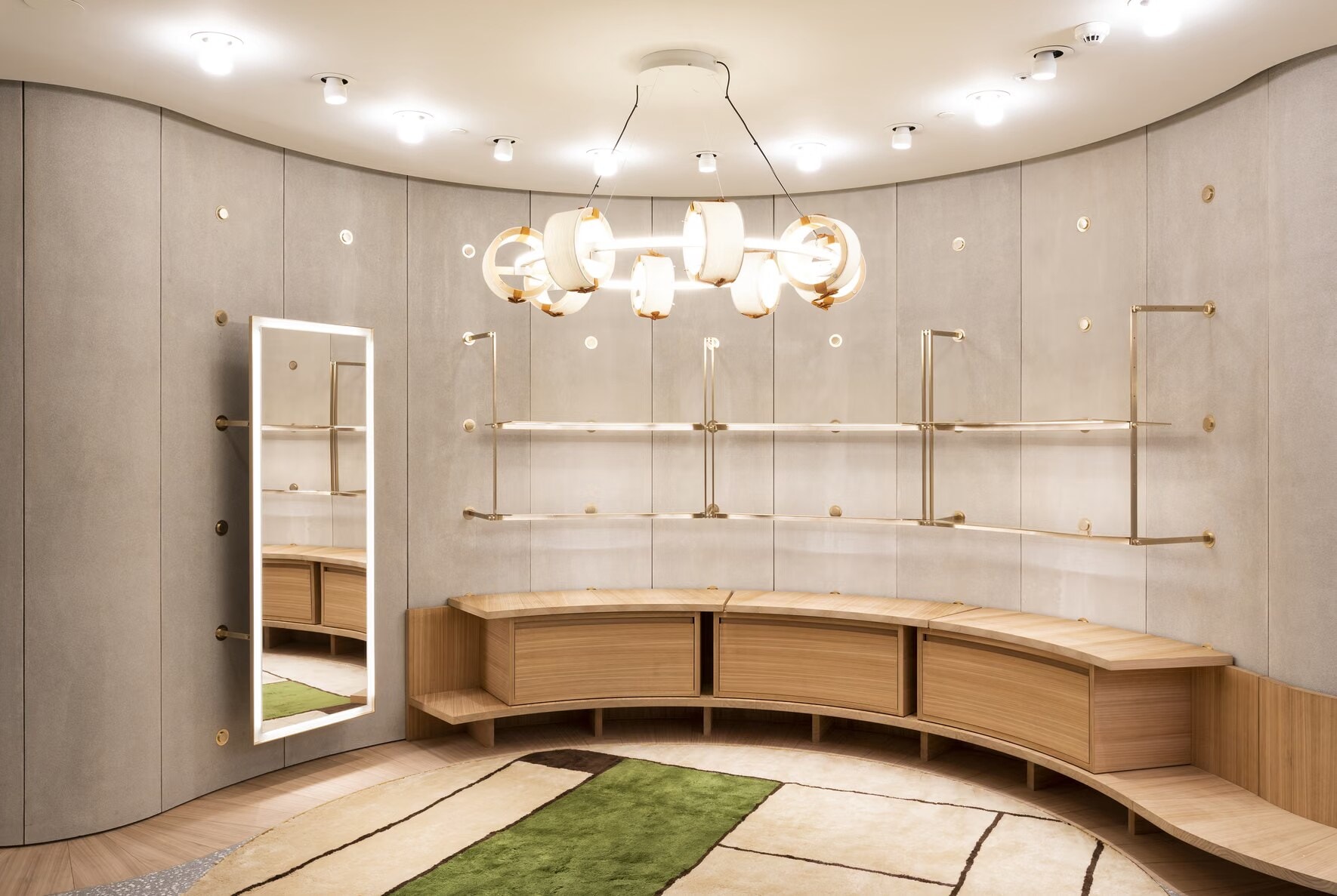 Curved timber bench seating and brass wall rails in the Valentino boutique