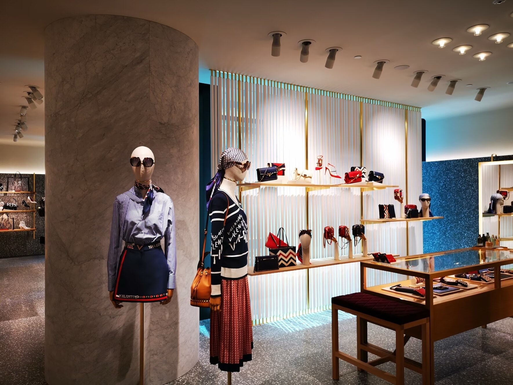 Valentino store shoe wall with brass shelves and mannequins