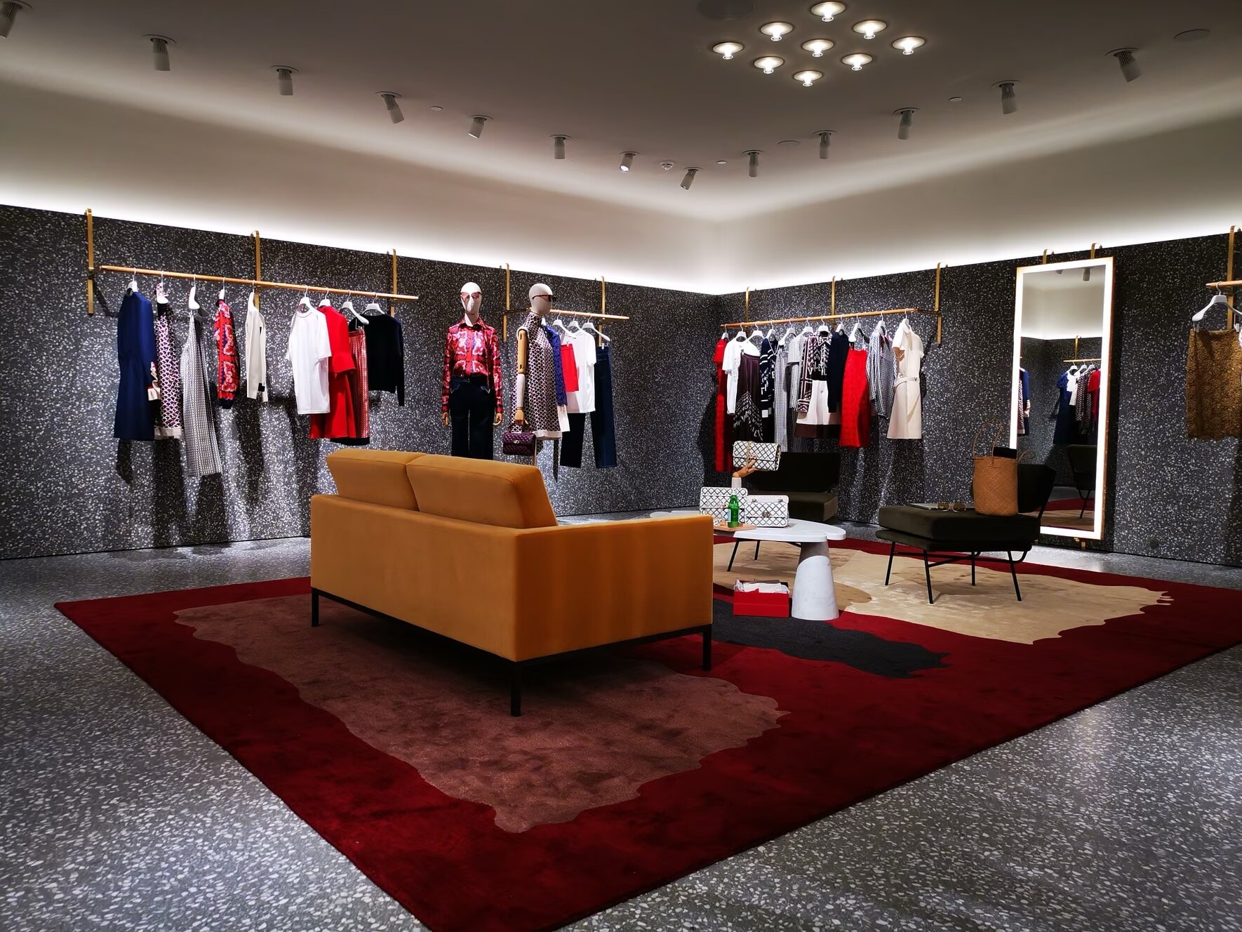 Valentino store lounge with rails, a sofa and a red rug