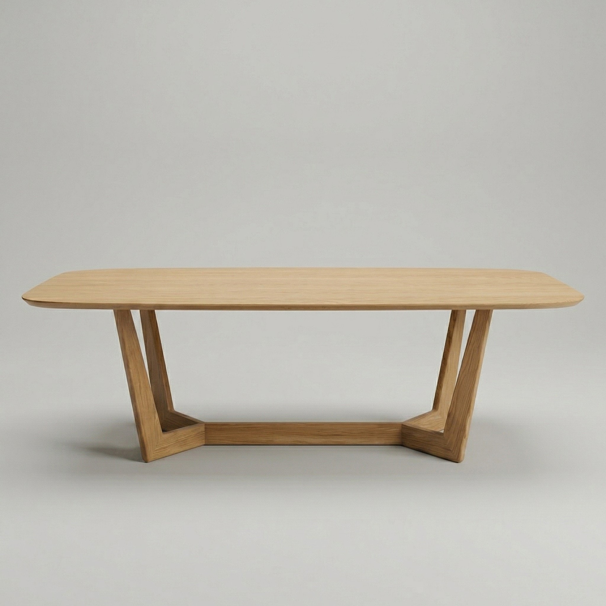 An American Oak dining table with a softly rounded top on angled timber legs joined by a low stretcher